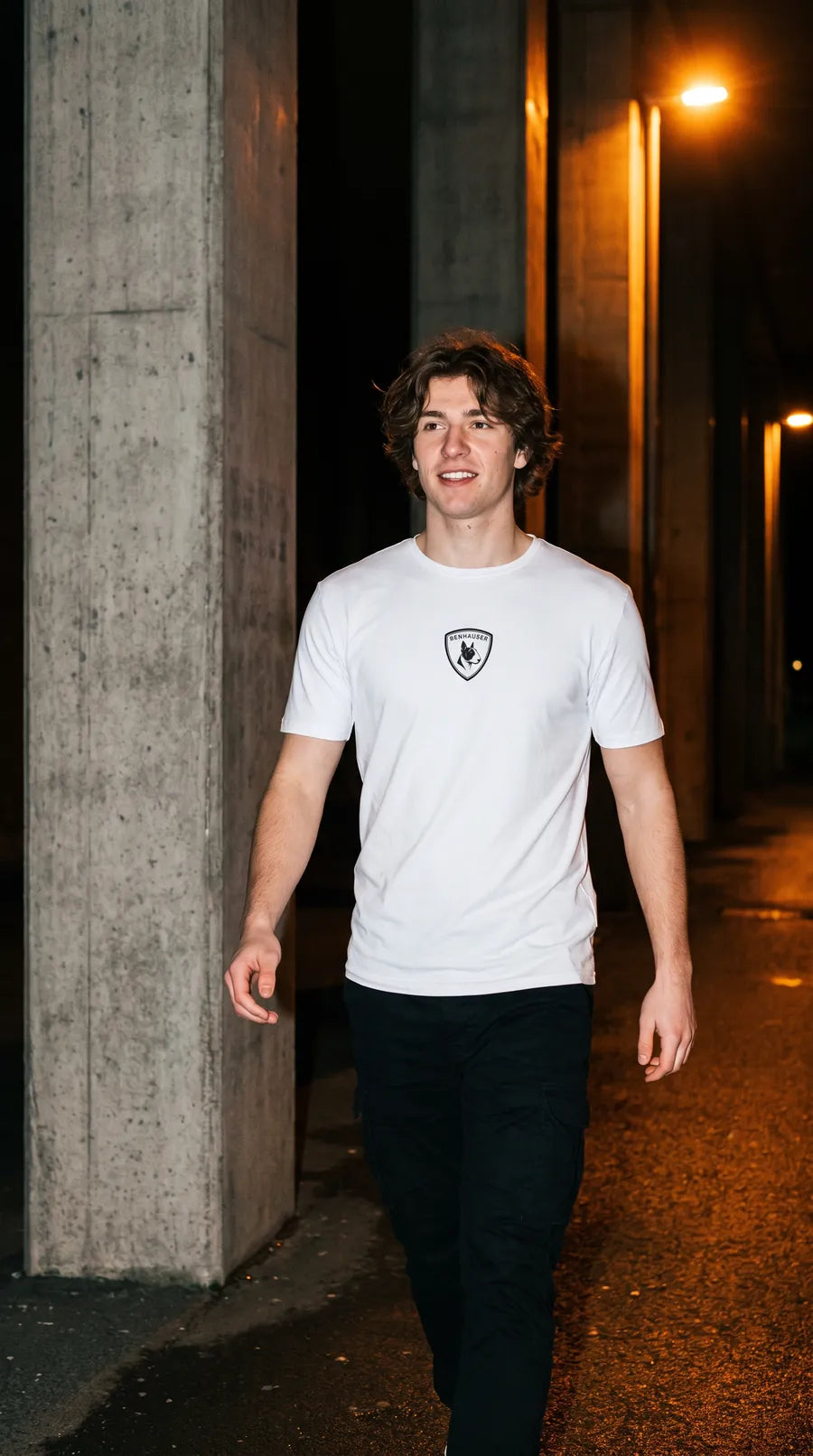 Mann im weißen Benhauser T-Shirt zwischen Betonsäulen