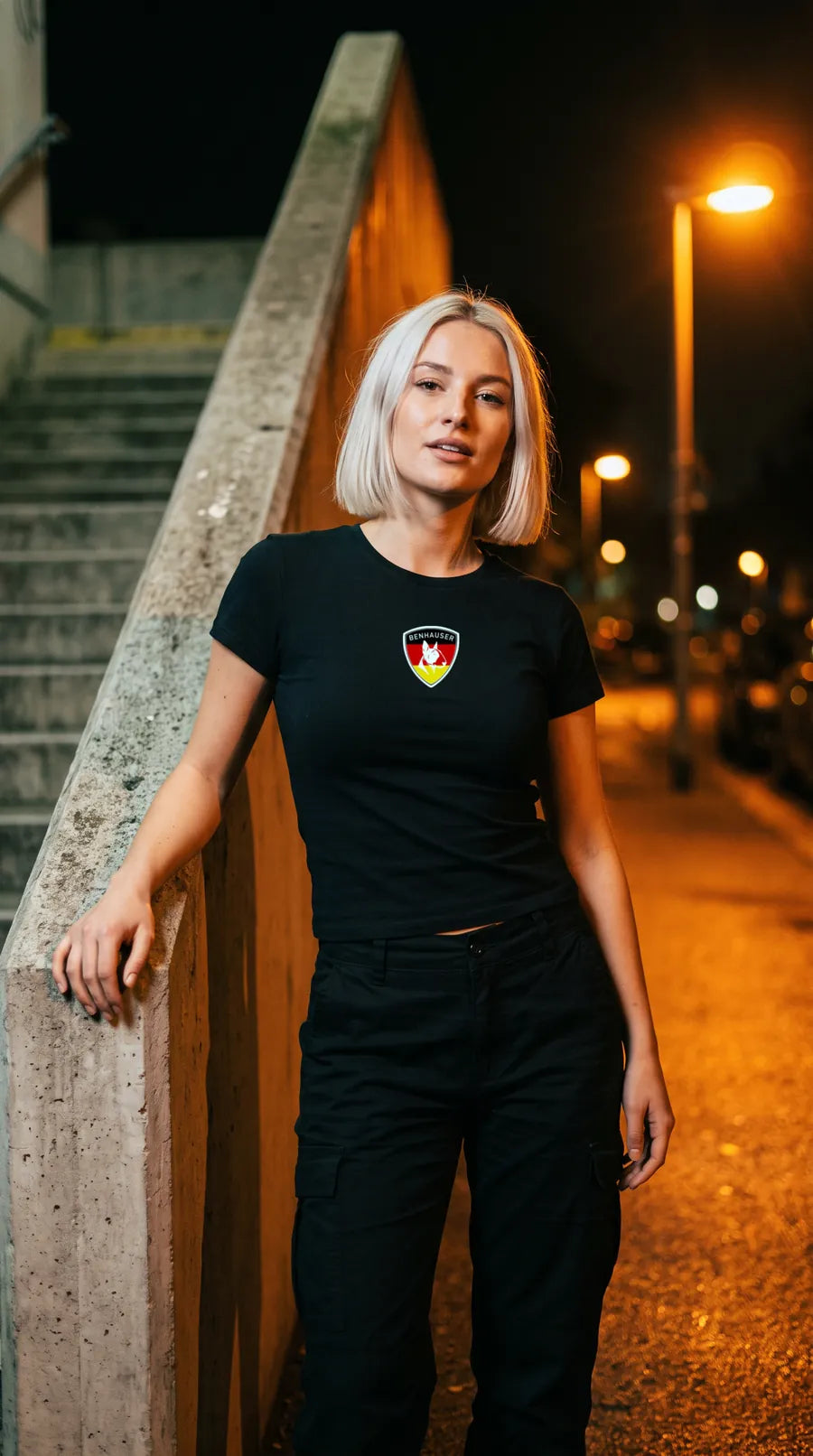 Frau im schwarzen Deutschland T-Shirt an einem Treppengeländer aus Beton